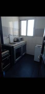 a small kitchen with a stove and a sink at Appartement Beau Séjour in Dakar