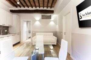 een woonkamer met een witte bank en een glazen tafel bij San Sebastiano Suite & Luxury Apartments in Colle di Val d'Elsa