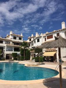 un hotel con piscina frente a un edificio en Cabo Roig Bellavista 26 en Playas de Orihuela