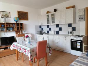 una cucina con tavolo e una cucina con armadietti bianchi di Ines and Marina a Dubrovnik