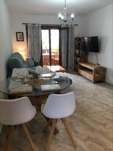 sala de estar con mesa y 2 sillas blancas en Cabo Roig Bellavista 26, en Playas de Orihuela