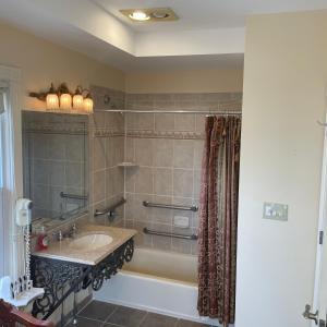 a bathroom with a sink and a tub and a shower at Laingdon Hotel in Ocean Grove
