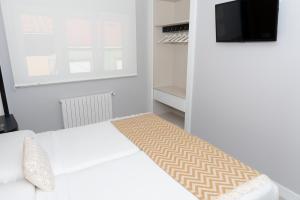 A bed or beds in a room at APARTAMENTOS CUME DO PINDO