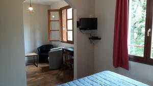 1 dormitorio con cama, escritorio y ventana en Le Relais de Boralde, en Espalion