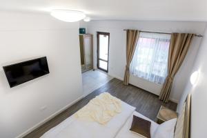 ein Wohnzimmer mit einem weißen Sofa und einem TV in der Unterkunft Brize Guesthouse in Tuzla