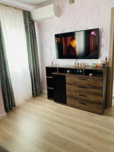 una sala de estar con TV de pantalla plana en una cómoda en Dina Lux Iasi Apartment en Iaşi
