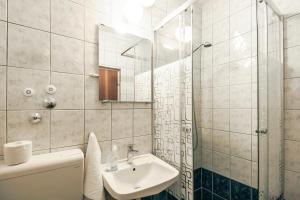 a white bathroom with a sink and a mirror at Apartments & Rooms Strčić Krk in Krk