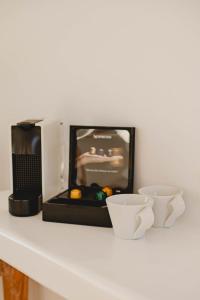 a microwave sitting on a counter with two cups at BAY VIEW RESIDENCE in Mikonos