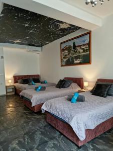 two beds in a room with a painting on the ceiling at Penelopa Apartments in Ohrid