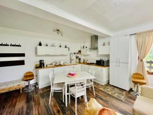 a kitchen with white cabinets and a table and chairs at Delux Apartment in Predeal