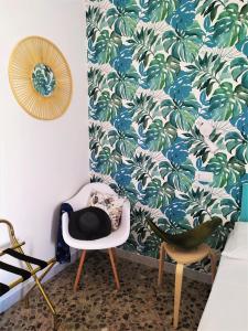 een kamer met 2 stoelen en behang met palmbomen bij A Polignano Rooms in Polignano a Mare