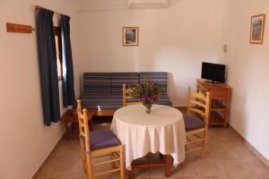 sala de estar con mesa, sillas y sofá en Can Pep Lluquinet en Es Pujols