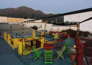 eine Gruppe bunter Stühle und Tische auf einem Dach in der Unterkunft Malecon en calle Techada Hostel in Capilla del Monte