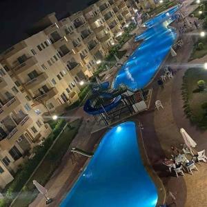 an aerial view of a swimming pool at a resort at Tahiti North cost تاهيتي الساحل الشمالي in Al Ḩammām