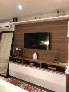 a living room with a flat screen tv on a wall at Flat Granja Brasil Itaipava in Petrópolis