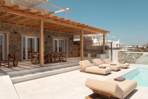 a villa with a swimming pool and a patio at Casa Del Mar - Small Luxury Hotels of the World in Agios Ioannis Mykonos