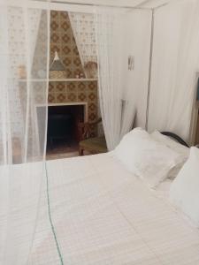 a white bed in a room with a fireplace at masseria chianca " Le Gravine" in Mottola