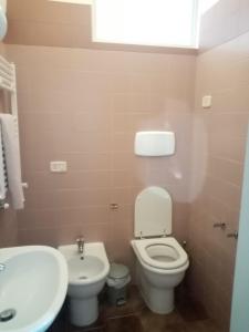 uma casa de banho com um WC branco e um lavatório. em masseria chianca " Le Gravine" em Mottola