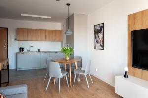 cocina y comedor con mesa y sillas en Apartament Harmony 93 en Gdynia