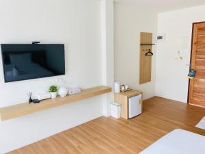 a living room with a flat screen tv on a wall at Busaba Bella Hotel in Sichon