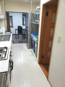 uma cozinha com um fogão e uma porta para um quarto em Within walking distance of Disneyland! - Vacation STAY 11473 em Urayasu