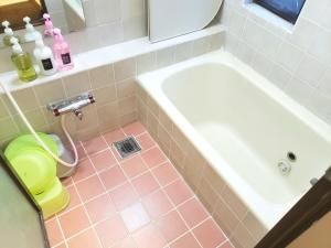 uma casa de banho com uma banheira branca e um piso de azulejo cor-de-rosa. em Within walking distance of Disneyland! - Vacation STAY 11473 em Urayasu