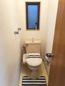 a small bathroom with a toilet and a window at Within walking distance of Disneyland! - Vacation STAY 11473 in Urayasu