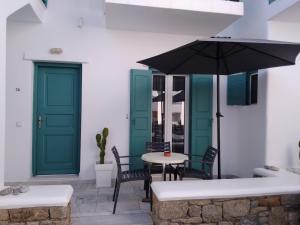 un patio con un tavolo e un ombrellone di Celeste Apartments a Ornos
