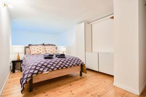 ein Schlafzimmer mit einem Bett und einer weißen Wand in der Unterkunft LocationsTourcoing - Le Loft two in Tourcoing