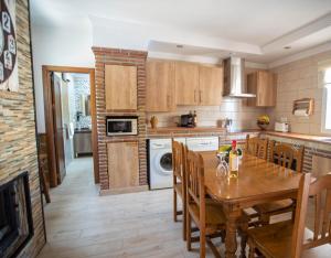 eine Küche mit einem Holztisch und einem Esszimmer in der Unterkunft Casa rural en Nerja Villa RuiSol by Centrall alquileres turísticos in Nerja