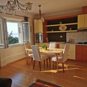 une cuisine avec une table et des chaises en bois ainsi qu'une salle à manger dans l'établissement Beach Apartments Lovran, à Lovran
