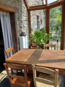 un tavolo in legno con sedie in una stanza con finestra di Maison Druyard huis met 5 slaapkamers a Durbuy
