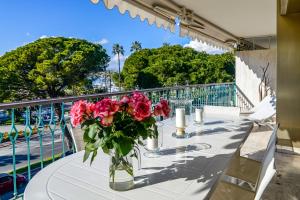 a vase of roses on a table on a balcony at IMMOGROOm- two terraces - Sea view - CROISETTE - AC in Cannes