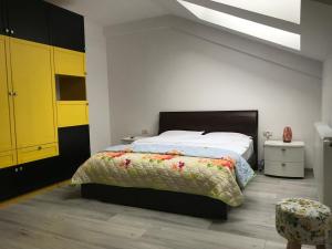 a bedroom with a bed and a yellow cabinet at Eli’s Apartament in Piatra Neamţ