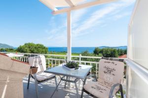 een patio met een tafel en stoelen op een balkon bij Villa Marina in Orebić