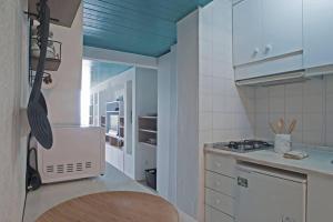 a kitchen with a sink and a stove top oven at Blue Studio Sesimbra - Com acesso privado à praia in Sesimbra