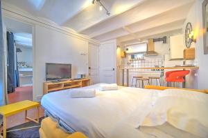 1 dormitorio con 1 cama blanca grande y cocina en IMMOGROOM - Cosy - City center - AC, en Cannes