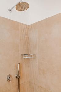 y baño con ducha con cabezal de ducha. en BAY VIEW RESIDENCE en Mykonos