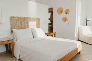 een witte slaapkamer met een groot bed en een bank bij BAY VIEW RESIDENCE in Mykonos-stad