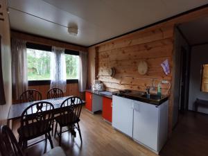 a kitchen and dining room with a table and chairs at Tommerneset Camping in Innhavet