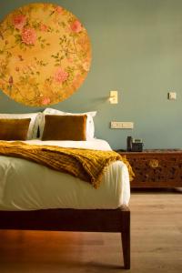 um quarto com uma cama com uma grande pintura na parede em Arte Nova Guesthouse na Covilhã