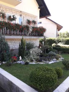 un jardín frente a una casa con flores en Apartment Petra en Mrkopalj