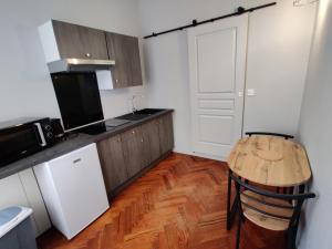 a kitchen with a wooden table and a wooden floor at La Victorine in Raismes