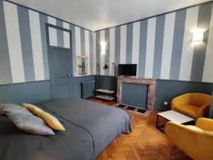 Schlafzimmer mit einem Bett, einem TV und einem Stuhl in der Unterkunft La Victorine in Raismes