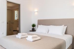a bedroom with a bed with two towels on it at DeKo Villa Mykonos in Ano Mera +29 photos