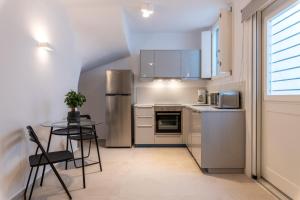 a kitchen with a table and a stainless steel refrigerator at DeKo Villa Mykonos in Ano Mera