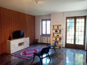 a living room with two chairs and a television at VILLA FERNANDO in Castagnole Lanze