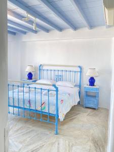 um quarto com uma cama azul e duas mesas de cabeceira em Blue Harmony Suites of Mykonos em Míconos