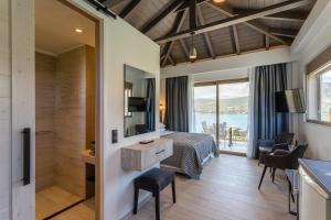 a hotel room with a bed and a bathroom at Lighthouse Apartments in Stoupa