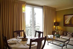 a dining room with a table and a large window at Los Altos Apartments & Studios in Managua